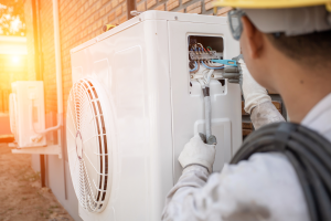 Technician working on an air source heat pump
